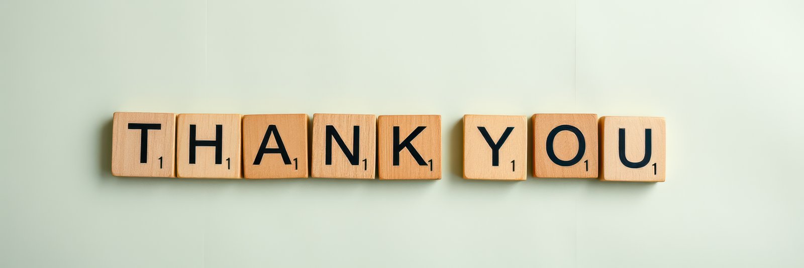 Creative expression of gratitude using wooden letter tiles arranged on a light background